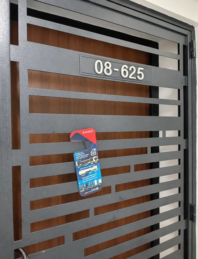 An Ariston promotional door hanger placed on a household gate.